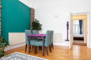 倫敦的住宿－Central 2 Bedroom Apartment near Old Street，一间用餐室,配有一张紫色的桌子和蓝色的椅子