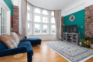 a living room with a blue couch and a tv at Central 2 Bedroom Apartment near Old Street in London