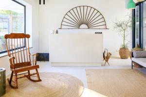 a living room with a rocking chair and a table at Domìa Boutique Hotel e Cucina in Mondello