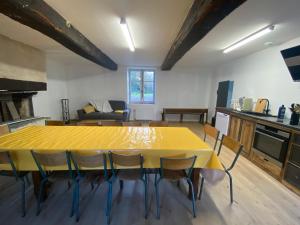 cocina con mesa amarilla y sillas en una habitación en Le Château de La Beauvais, en Piré-sur-Seiche