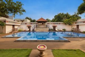 Chidambara Vilas - A Luxury Heritage Resort في Kānādukāttān: مسبح كبير مع شرفة في ساحة الفناء