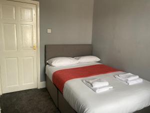 a bedroom with a bed with towels on it at Alexander Apartments Tyneside in Gateshead