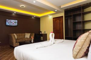 una camera d'albergo con un letto con cigni sopra di Sahara Gardens Bomet a Bomet