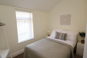 a white bedroom with a bed and a window at The Hideout, IH4AOXF in Middlesbrough