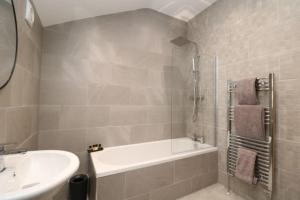 a bathroom with a tub and a sink and a bath tub at The Hideout, IH4AOXF in Middlesbrough