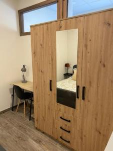 1 dormitorio con armario de madera y espejo en El Embarcadero, en Boó de Piélagos