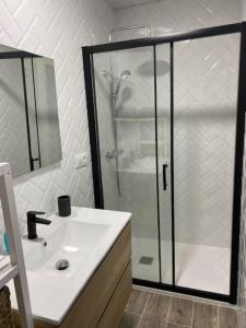 a bathroom with a shower and a white sink at El Embarcadero in Boó de Piélagos