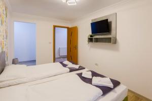 a bedroom with two beds and a tv on the wall at VAiAs Aparts in Tîrgu Neamţ