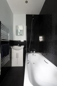 a black and white bathroom with a tub and a sink at Superfast WiFi studio, bathroom & own entrance in Brighton & Hove