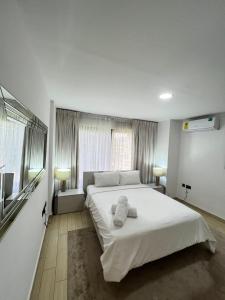 a bedroom with a large white bed with towels on it at Hilton Premium Suite, Labone in Accra