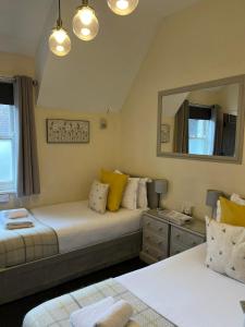 a bedroom with two beds and a mirror at The White Hart in Newenden