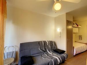 uma sala de estar com um sofá e uma cama em Studio Lamalou-les-Bains, 1 pièce, 2 personnes - FR-1-451-76 em Lamalou-les-Bains