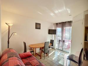 - un salon avec une table et un canapé dans l'établissement Appartement Lamalou-les-Bains, 2 pièces, 2 personnes - FR-1-451-107, à Lamalou-les-Bains