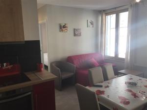 - un salon avec un canapé rouge et une table dans l'établissement Appartement Mont-Dore, 3 pièces, 6 personnes - FR-1-415-69, à Le Mont-Dore