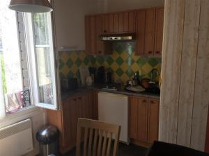 a small kitchen with wooden cabinets and a window at Appartement Mont-Dore, 3 pièces, 4 personnes - FR-1-415-61 in Le Mont-Dore