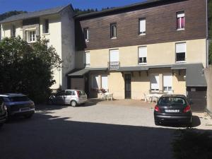 een gebouw met twee auto's geparkeerd op een parkeerplaats bij Appartement Mont-Dore, 3 pièces, 4 personnes - FR-1-415-61 in Le Mont-Dore