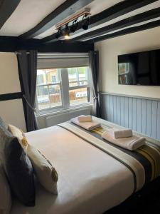 a large bed in a room with a window at The White Hart in Newenden