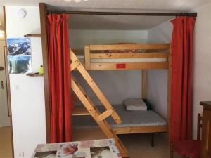 ル・モンドールにあるAppartement Mont-Dore, 2 pièces, 6 personnes - FR-1-415-62の赤いカーテンが備わるドミトリールームの二段ベッド1台分です。