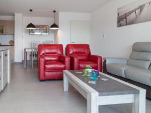 una sala de estar con 2 sillas rojas y una mesa. en Appartement Capbreton, 3 pièces, 4 personnes - FR-1-239-387, en Capbreton