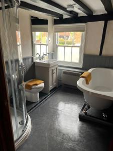 a bathroom with a shower and a sink and a toilet at The White Hart in Newenden