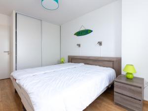 カップブルトンにあるAppartement Capbreton, 3 pièces, 4 personnes - FR-1-239-387のベッドルーム(大きな白いベッド1台、緑のランプ付)