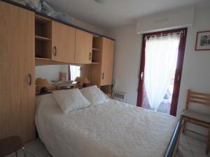 1 dormitorio con cama blanca y ventana en Appartement Arcachon, 2 pièces, 4 personnes - FR-1-474-19, en Arcachon