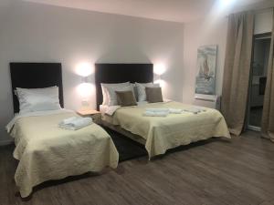 a hotel room with two beds and two lamps at Elvis Rooms Airport in Velika Gorica