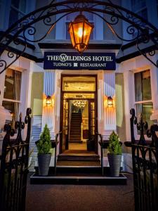 a hotel entrance with a sign that reads the wilkes hotel at The Wildings Hotel & Tudno's Restaurant in Llandudno
