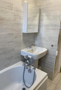 a bathroom with a sink and a bath tub at Spacious 1 bedroom flat in London in London