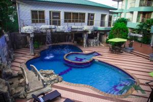 a swimming pool in front of a house at Ange Hill Hotel in Accra