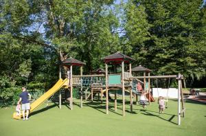 eine Gruppe von Kindern, die auf einem Spielplatz spielen in der Unterkunft Huttopia Beaulieu sur Dordogne in Beaulieu-sur-Dordogne