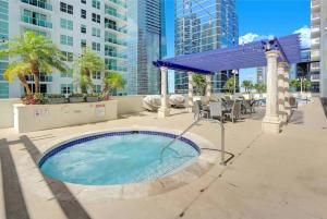 a hot tub in a patio with tables and chairs at Deluxe 1 BR suite with Pool, Parking, Balcony and Ocean Views in Miami