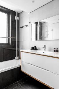 a bathroom with a sink and a tub and a mirror at JAFFA - Authentic Collection - By HOMY in Tel Aviv