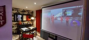 un grande schermo di proiezione in una stanza con tavolo di Appartement Cinéma vidéo-projecteur et garage a Honfleur