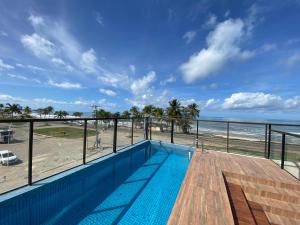 a swimming pool with a view of the beach at Residencial SAN MARINO BEIRA MAR in Ilhéus