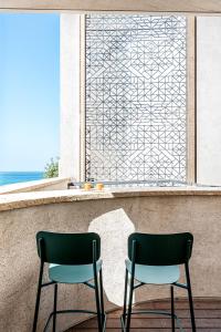 two chairs sitting in front of a window at JAFFA - Authentic Collection - By HOMY in Tel Aviv