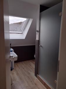 a bathroom with a skylight and a toilet and a door at Fewo nahe der Ostsee bei Lübeck in Lauen