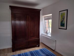 a room with a wooden cabinet and a window at Fewo nahe der Ostsee bei Lübeck in Lauen