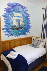 un dormitorio con una pintura de un barco en la pared en Peerboom Guesthouse, en Fouriesburg