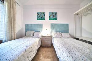 - 2 lits dans une chambre avec des draps bleus et blancs dans l'établissement La Casa del Olivo, à Navahermosa