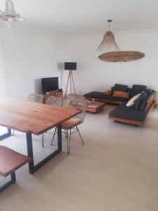 a living room with a wooden table and chairs at Jardins da Falesia in Albufeira