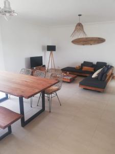 Una sala de estar con una mesa y sillas de madera. en Jardins da Falesia, en Albufeira