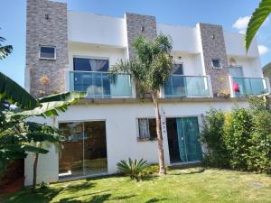 a house with large windows and a palm tree at Pousada Beach Eco House Floripa Com Ar Condicionado in Florianópolis