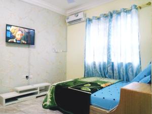 a bedroom with a bed and a tv on the wall at City Stay lodging center in Botianaw