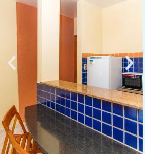 uma cozinha com azulejos azuis no balcão e um frigorífico em Boulevard da Praia Hotel em Porto Seguro