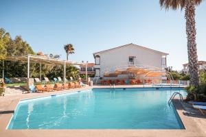 a swimming pool with chairs and a water slide at Hydrele Beach Hotel & Village in Potokáki