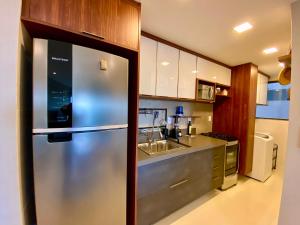 uma cozinha com um frigorífico de aço inoxidável e um lavatório em Residencial SAN MARINO BEIRA MAR em Ilhéus