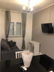 ein Wohnzimmer mit einem Sofa und einem TV an der Wand in der Unterkunft 13 Minuti Dal Centro in Reggio di Calabria