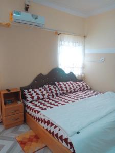 a bedroom with a bed with red and white pillows at City Stay lodging center in Botianaw