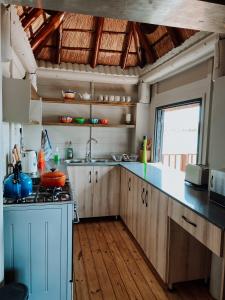 a kitchen with wooden cabinets and a stove top oven at Hluhluwe Bush Camp in Hluhluwe